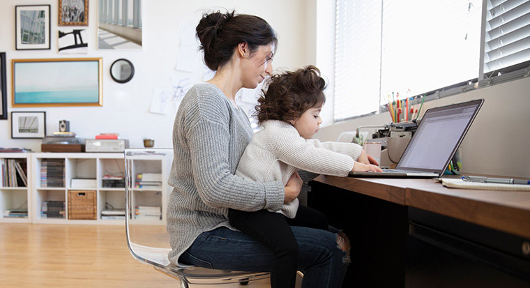 Mother and child typing on a laptop