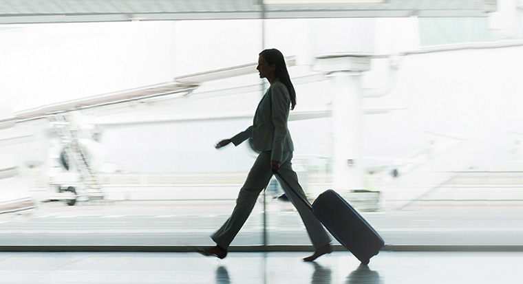 woman walking through airport with luggage