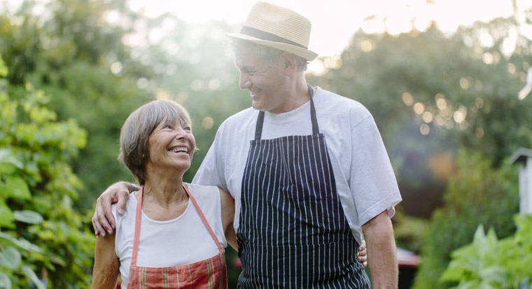 Happy senior couple walking in garden