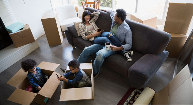 Family unpacking boxes in new house