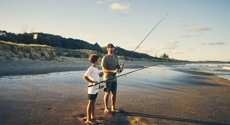 Father and son fishing on beach