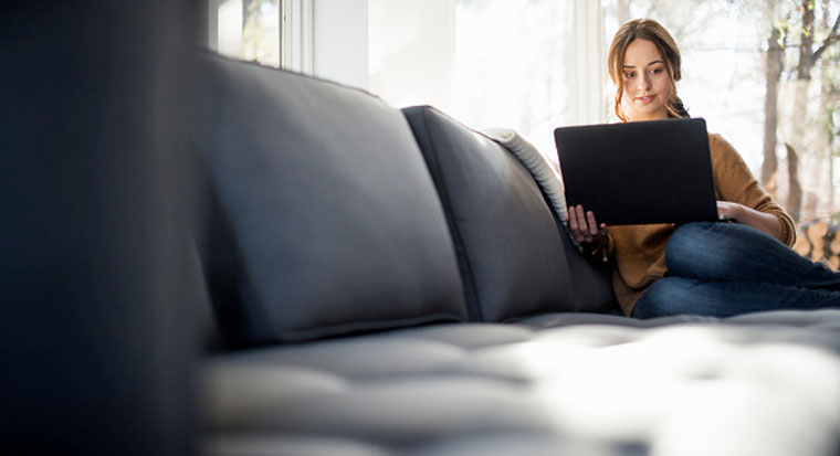 Woman looking at laptop on couch