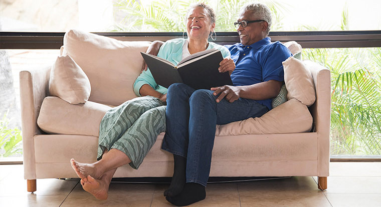 An elderly couple looking through a photo album