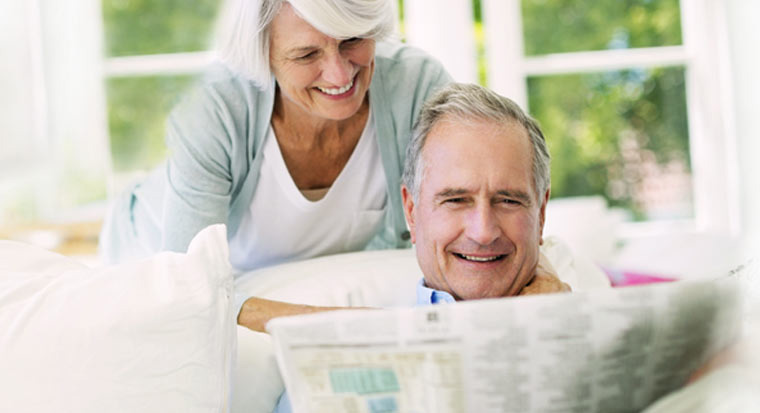 Retired man and woman with newspaper