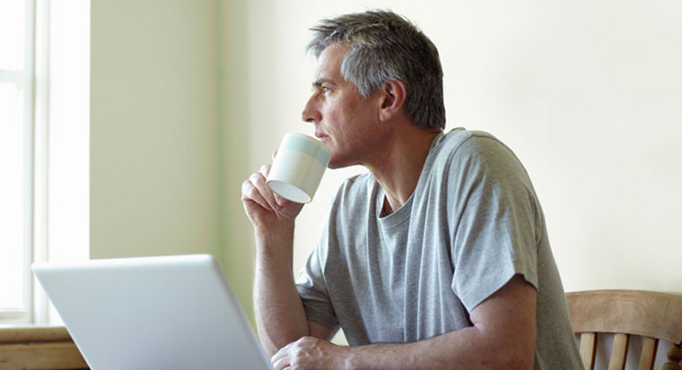 retired man with coffee and laptop