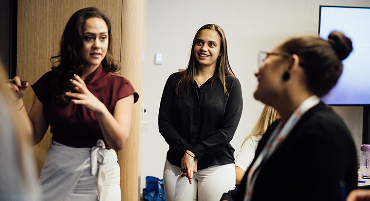 Image of three women standing talking 